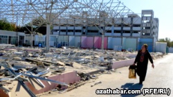 Женщина идет вдоль разрушенного базара в Ашгабате.